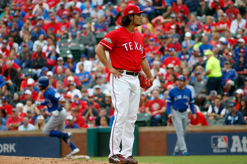 Texas Rangers starting pitcher Yu Darvish (11) reacts after giving up a home run to Toronto...