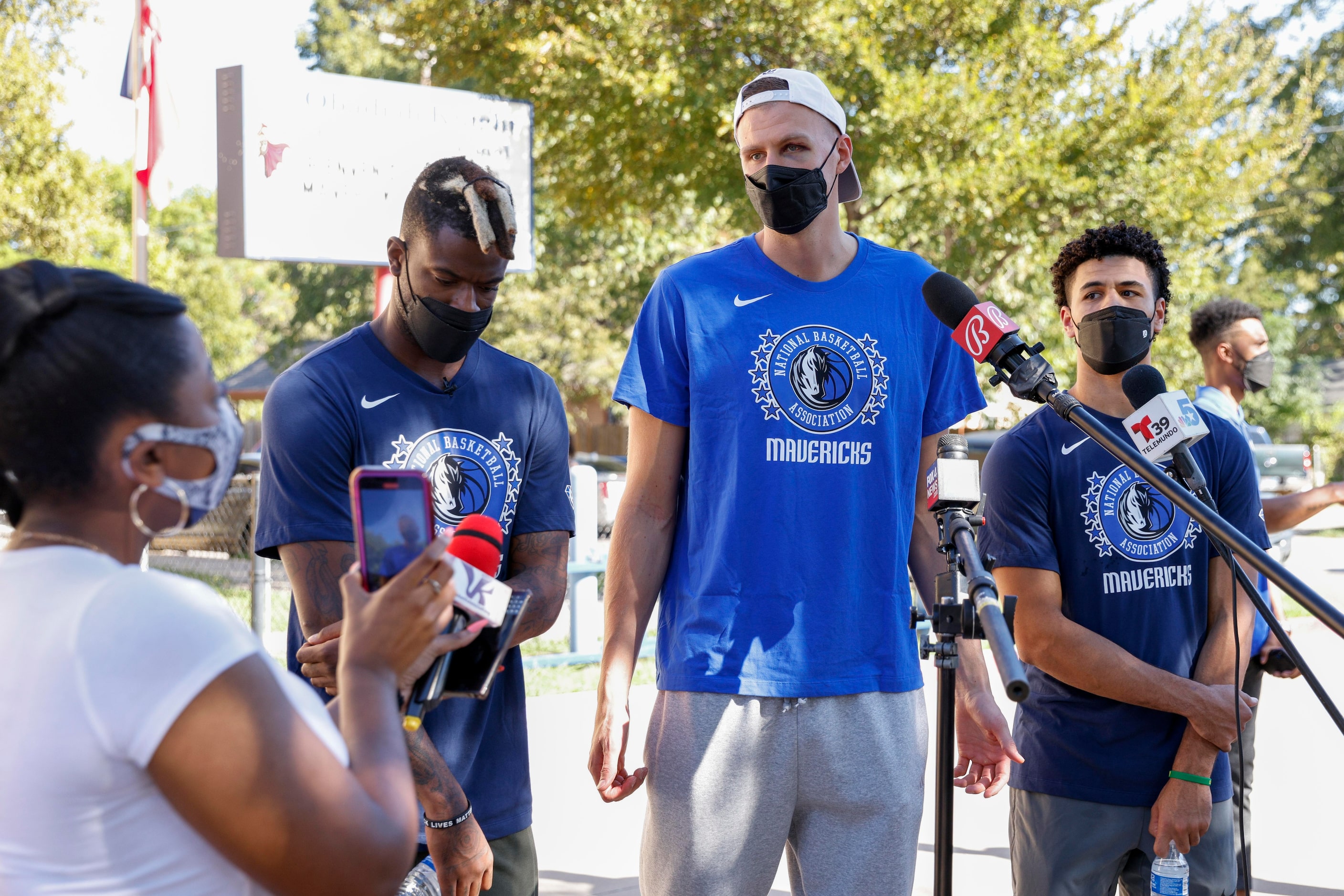 Dallas Mavericks small forward Reggie Bullock (left), center Kristaps Porzingis (center) and...