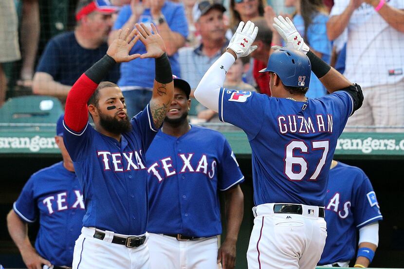 ARLINGTON, TX - MAY 23:  Rougned Odor #12 of the Texas Rangers greets Ronald Guzman #67 of...