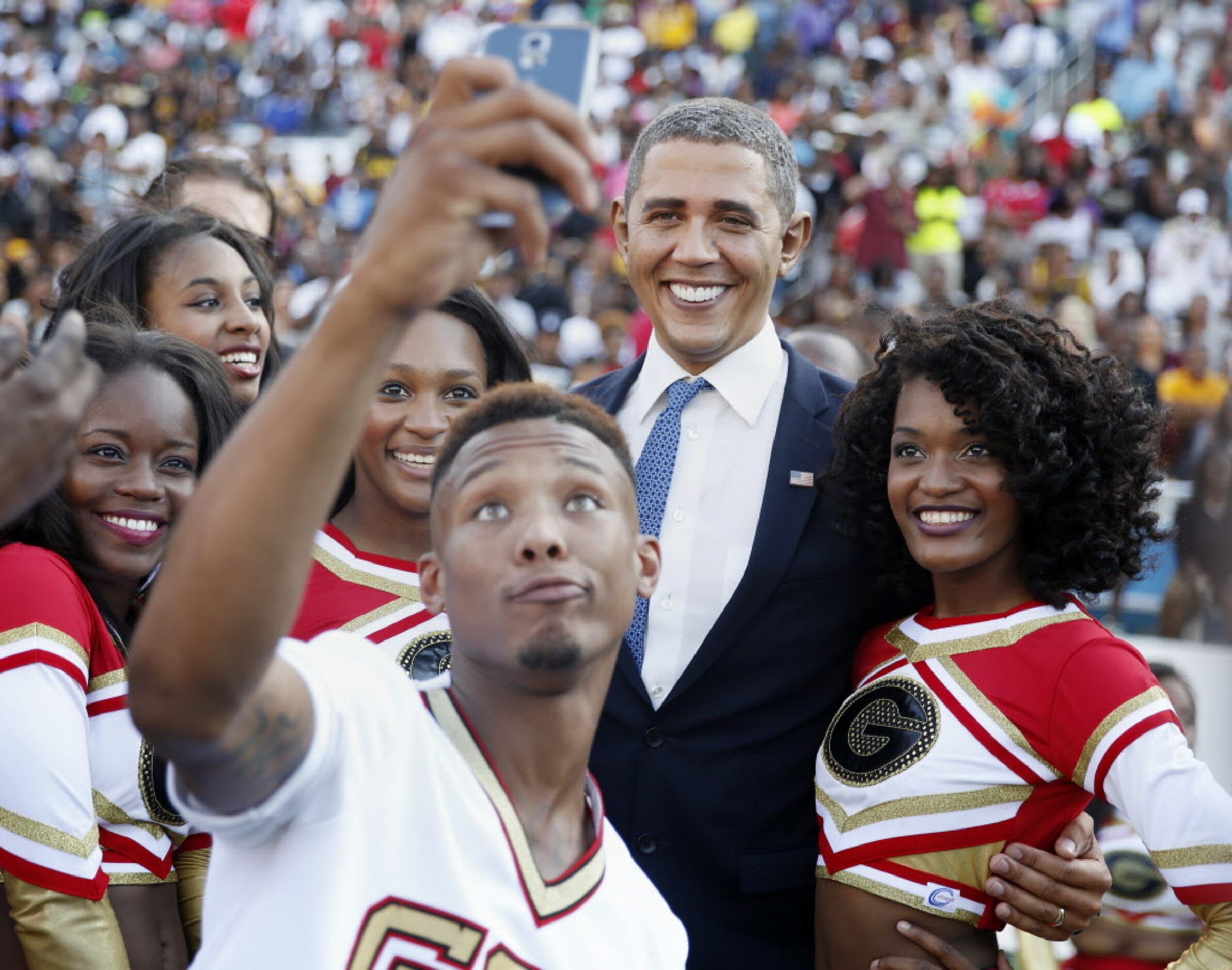 A Grambling cheerleader takes a selfie while an impersonator of President Barack Obama takes...