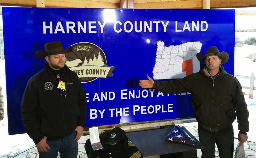 Ryan Bundy, right, gestures in front of a sign at the Malheur National Wildlife Refuge in...