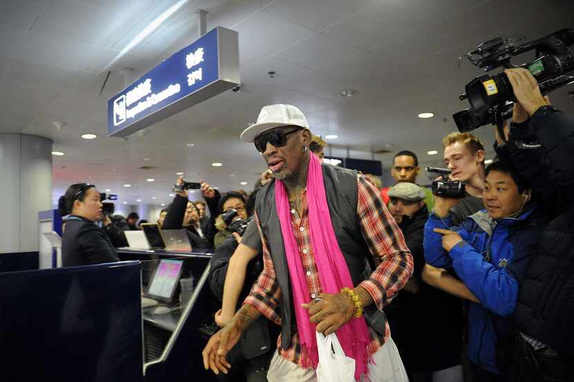 Former NBA basketball player Dennis Rodman of the US (C) walks past the media to check in...