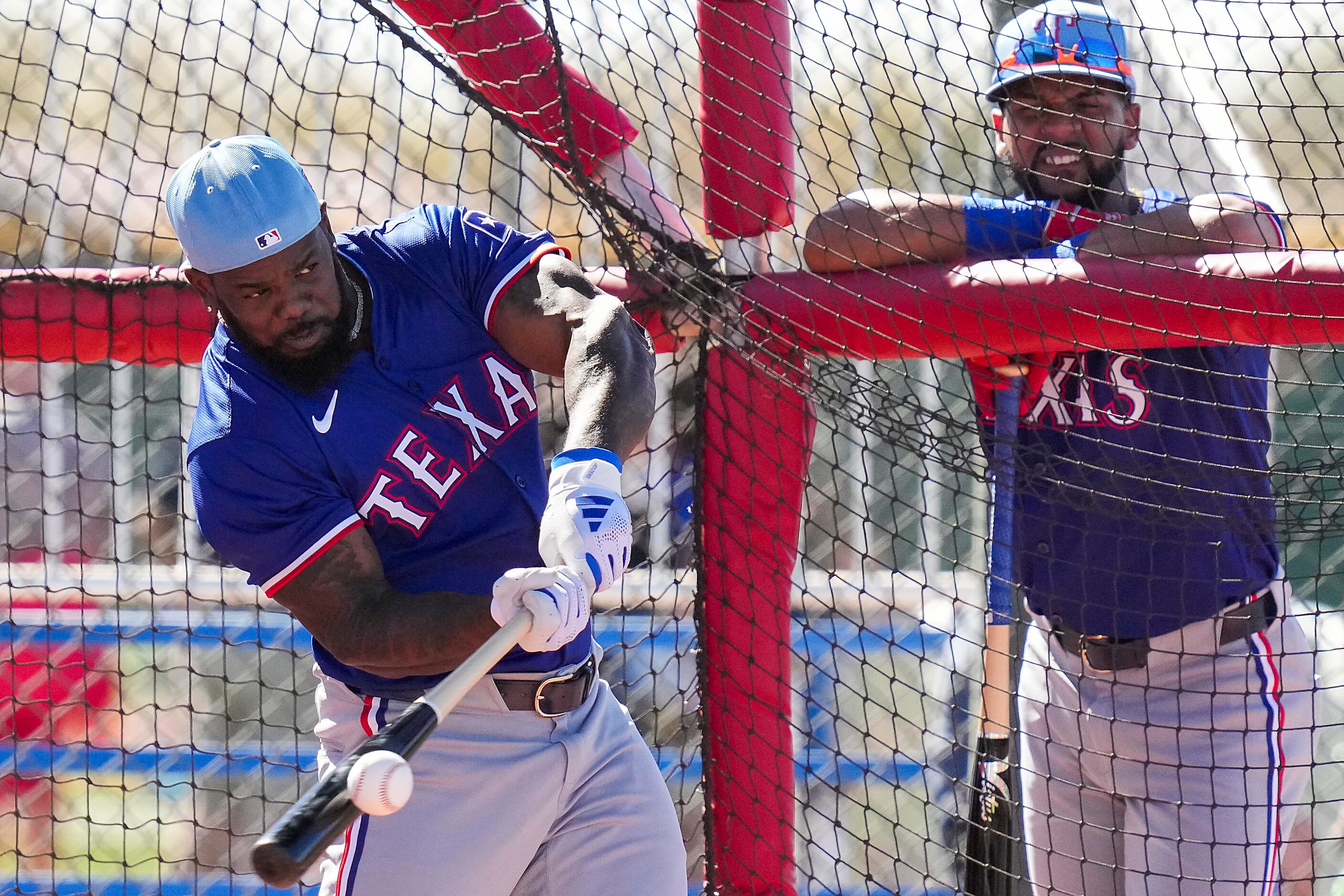 Texas Rangers outfielder Adolis García takes batting practice as outfielder Leody Taveras...