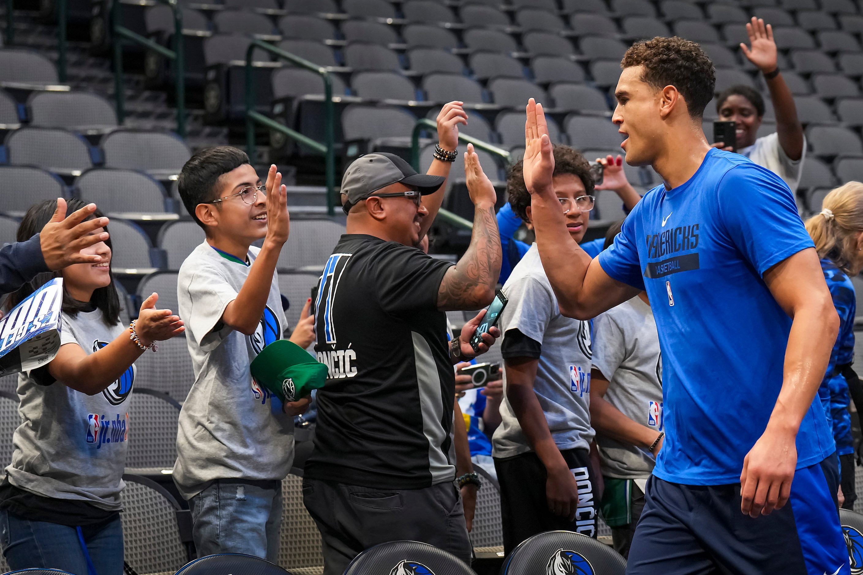 Dallas Mavericks center Dwight Powell high fives fans as he warms up before an NBA preseason...