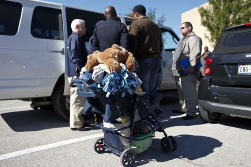 A stroller that a child was in rests outside a van while Dallas police and Child Protective...