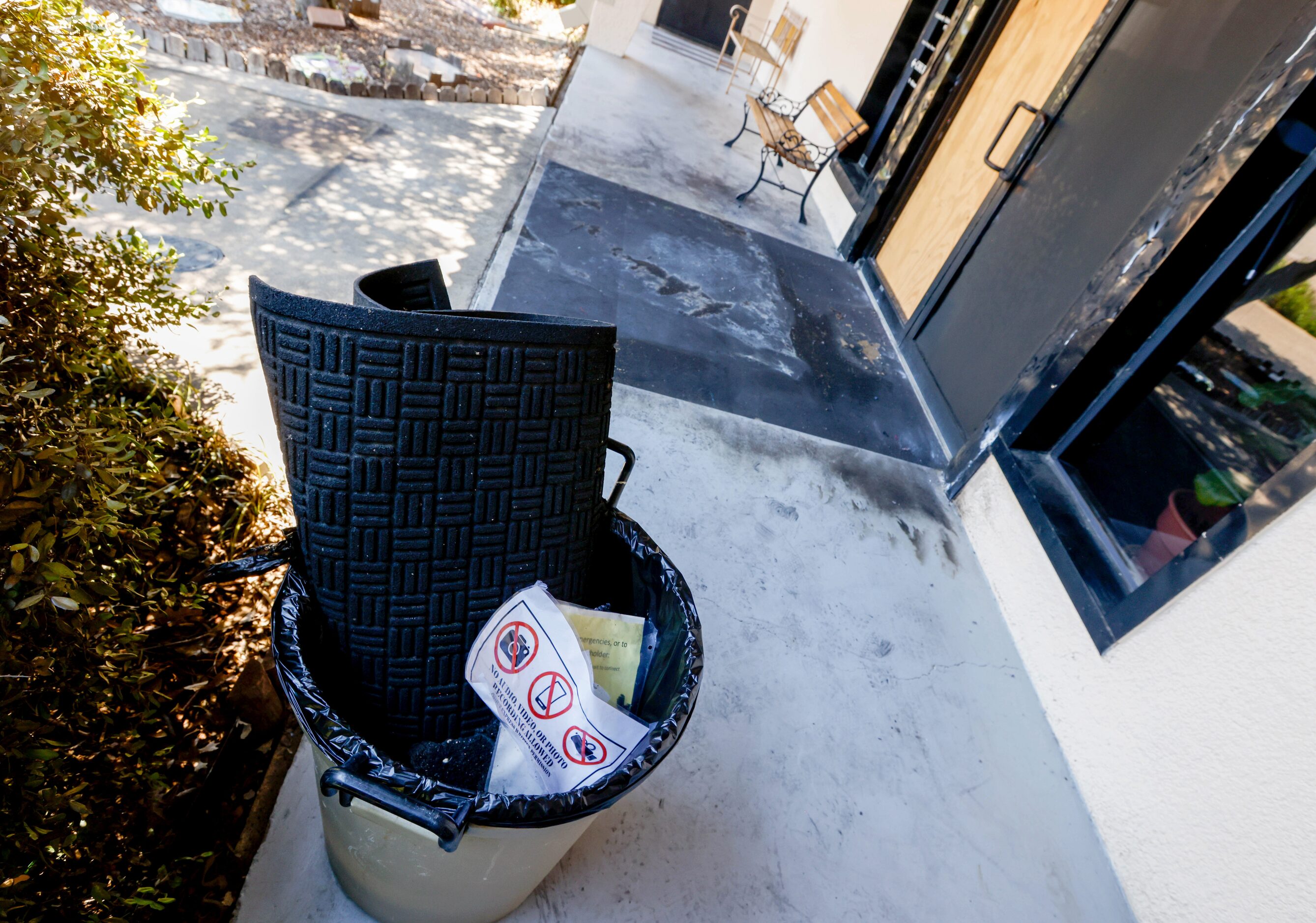 A trashcan sits to the side of the damaged doorway of Community Unitarian Universalist...