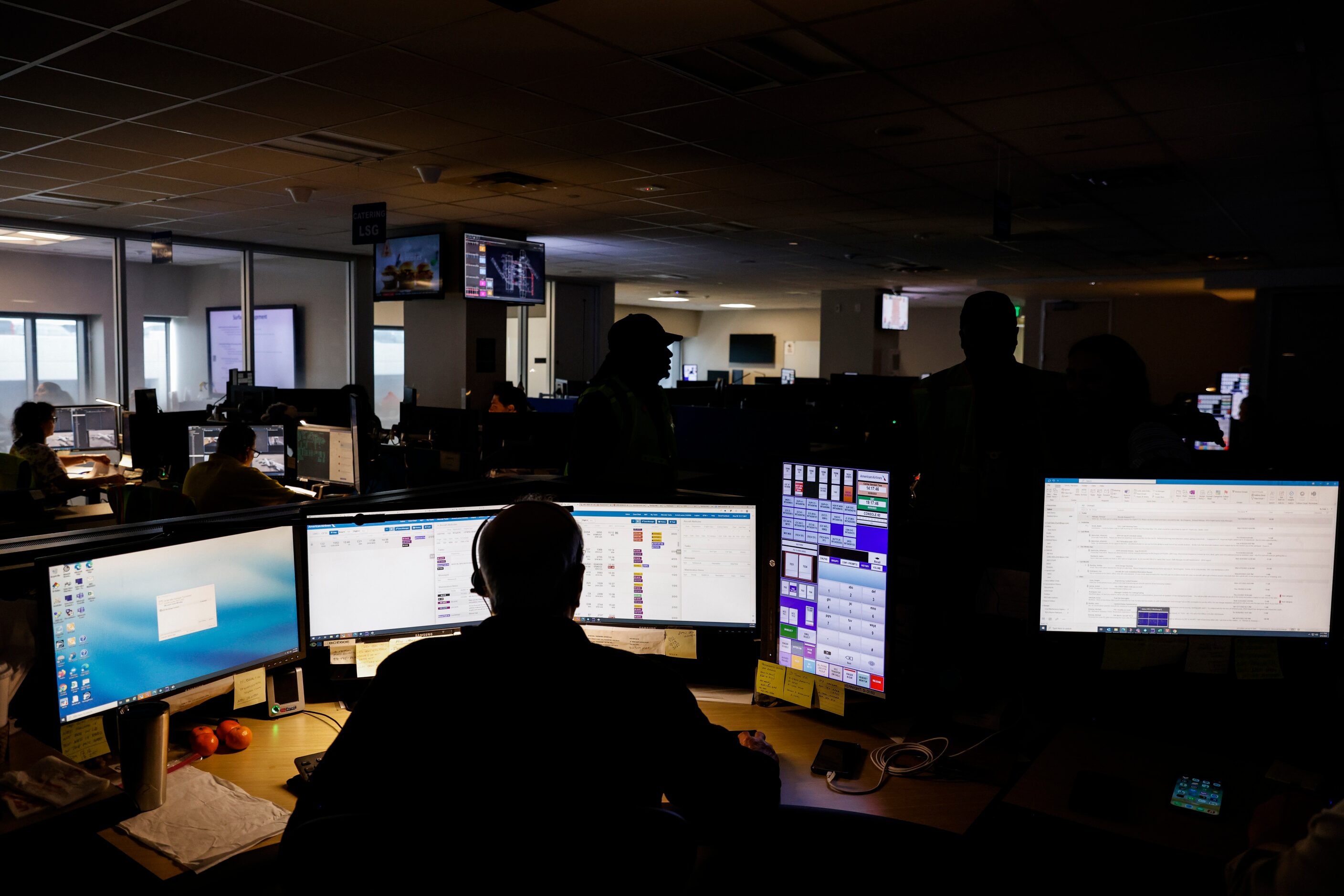 Employees work at American Airlines command center, where the airline directs its ground...