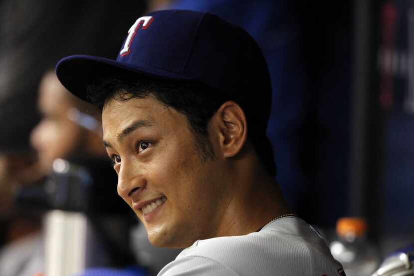 Texas Rangers starting pitcher Yu Darvish (11) smiles in the dugout during the seventh...