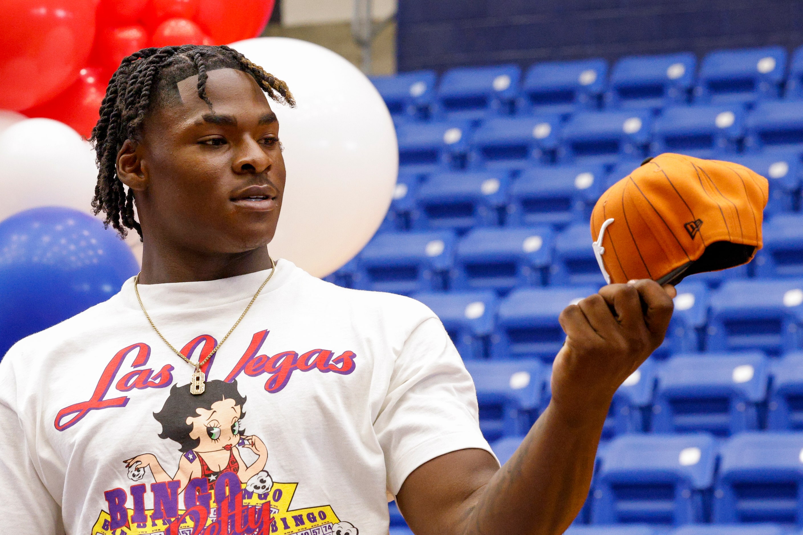 Duncanville defensive lineman Colin Simmons examines a University of Texas hat before...