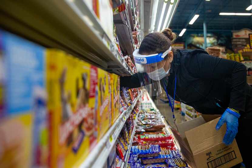 Rebecca Sierra restocks packaged meats at the El Rancho Supermercado on Gaston Avenue in...