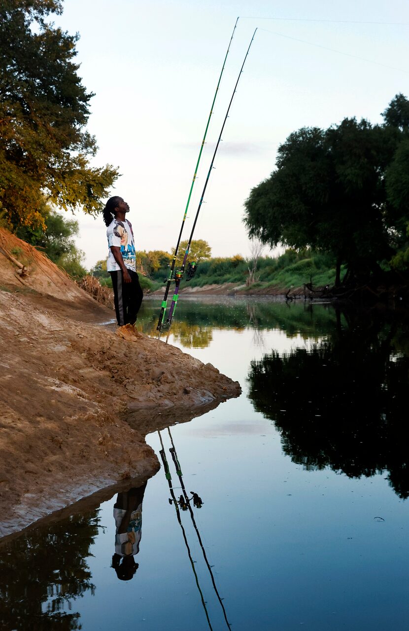 Odell Allen watches for an alligator gar bite on his lines along the Trinity River, Monday,...