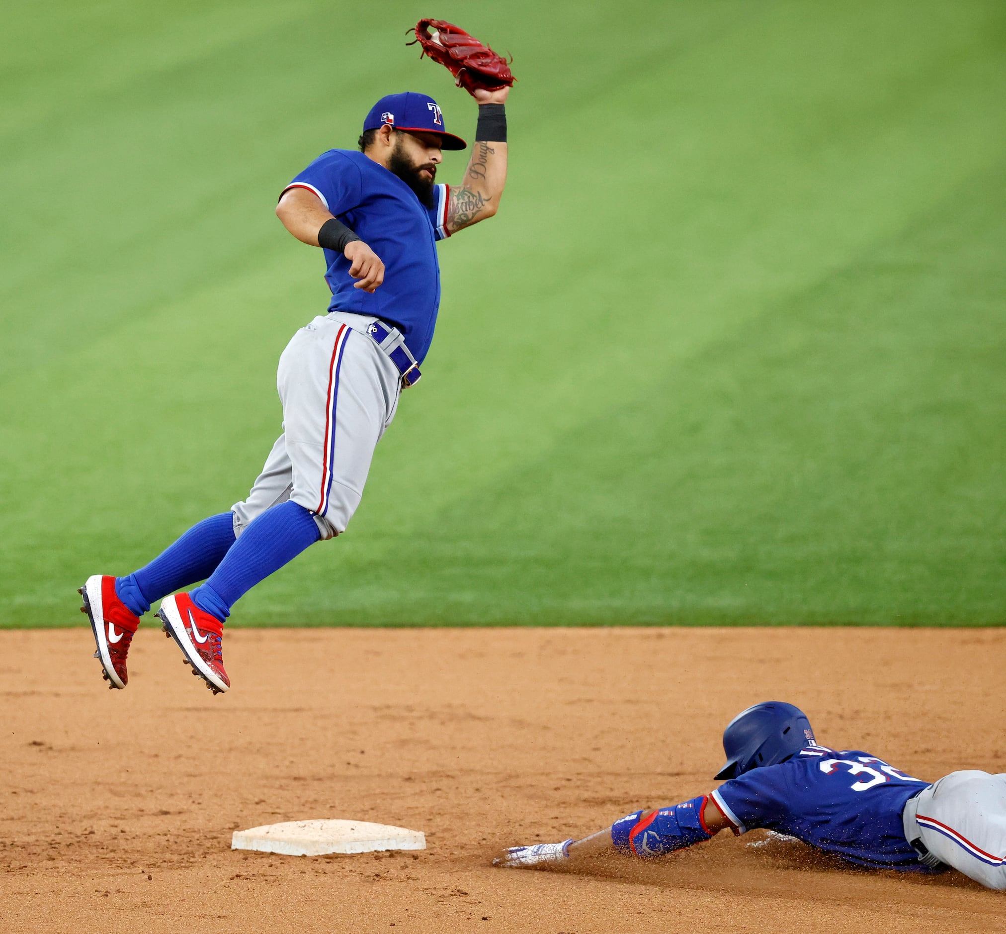 Texas Rangers second baseman Rougned Odor goes high for a throw-down attempt to get a...