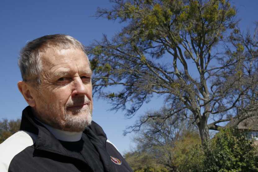 The Rev. Jim Murphree poses with a tree infested with mistletoe in Dallas.