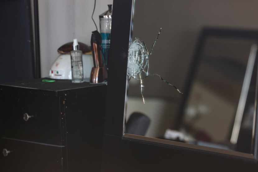 A shattered mirror is seen inside Hair World Salon on Thursday, May 12, 2022.
