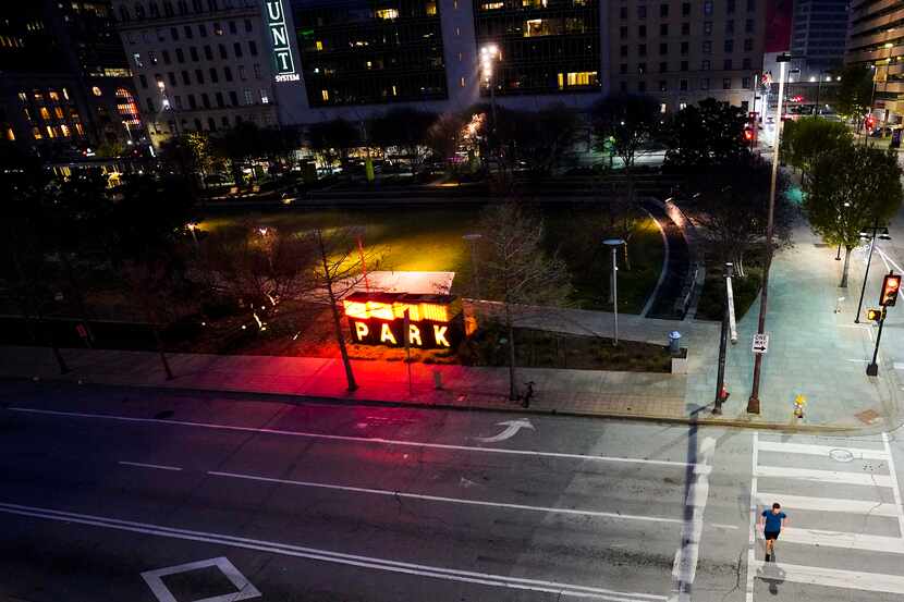 A man jogs through a empty crosswalk at the nearly empty Main Street Gardens after the city...