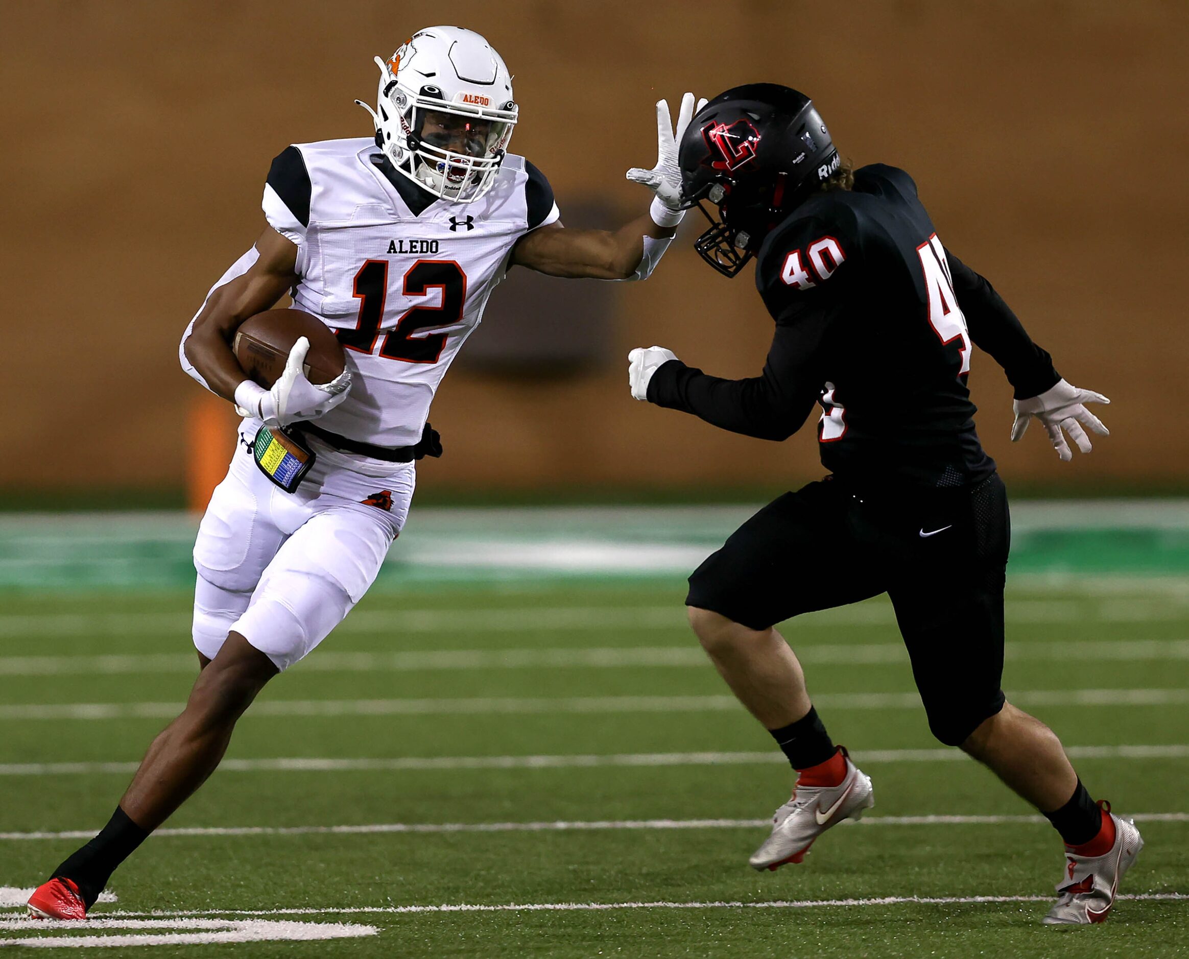 Aledo kick returner Brian Fleming (12) tries to get past Frisco Liberty's Ethan Ashmore (40)...