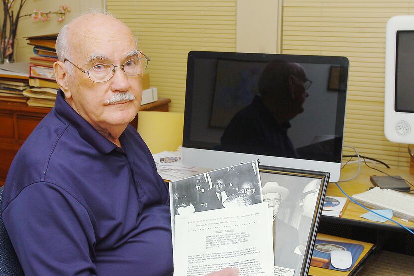 Former Dallas Times Herald reporter Keith Shelton holds momentos from President John F....