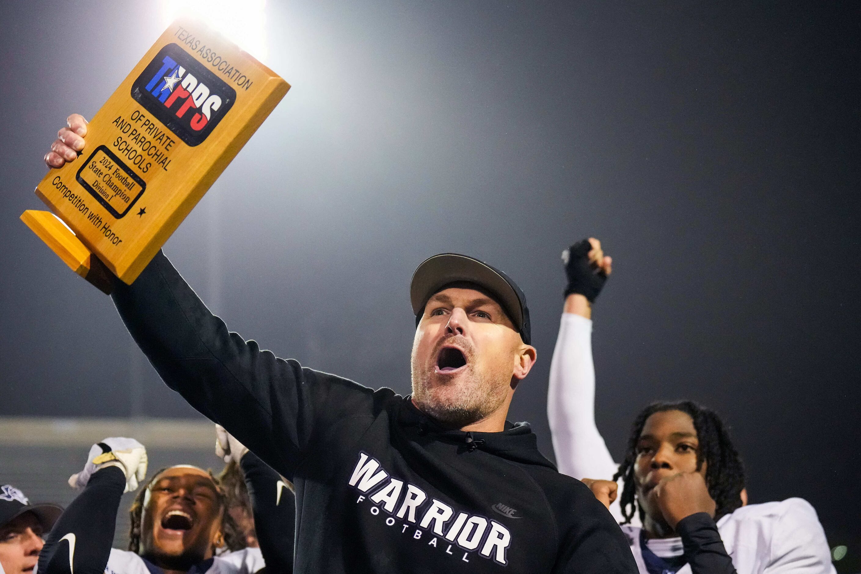 Argyle Liberty Christian head coach Jason Witten lifts the championship trophy after a 45-24...