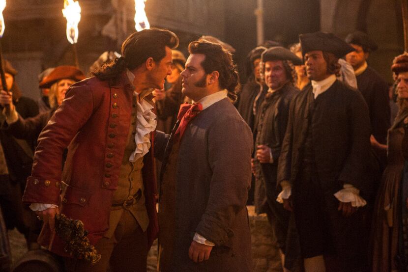 This image released by Disney shows Luke Evans as Gaston, left, with Josh Gad as LeFou, in...