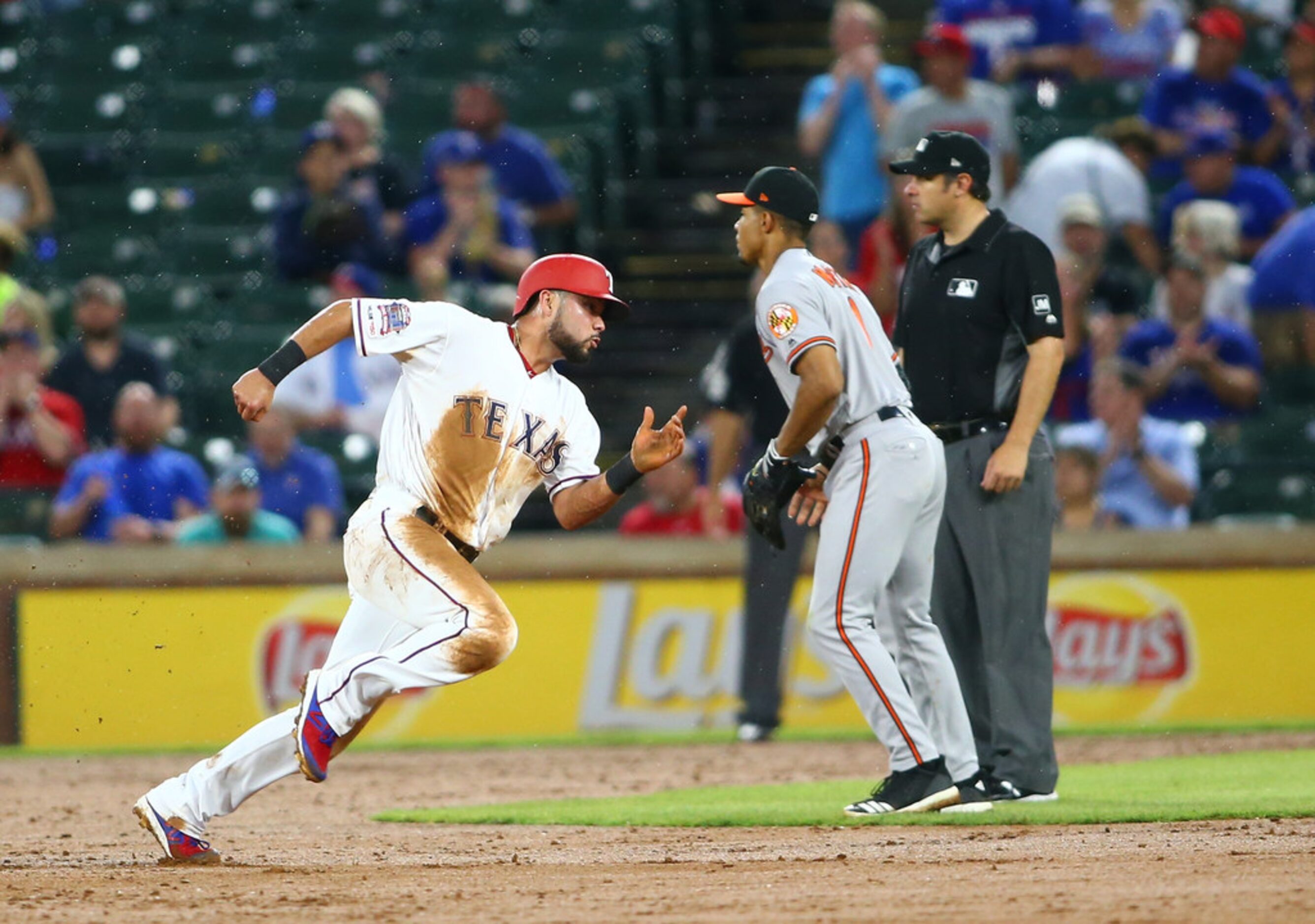 ARLINGTON, TX - JUNE 06: James Hoye #92 umpire looks ones on as Isiah Kiner-Falefa #9 of the...