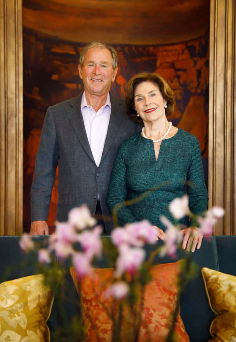 Former President George W. Bush and First Lady Laura Bush pose before a painting of the...