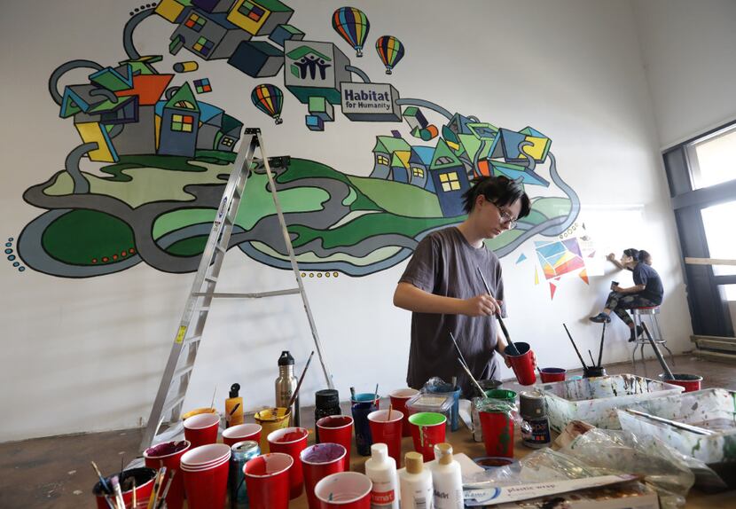 Suzanna Perry (left) and Masi Kafashhaghparast help paint a mural at the new Habitat For...