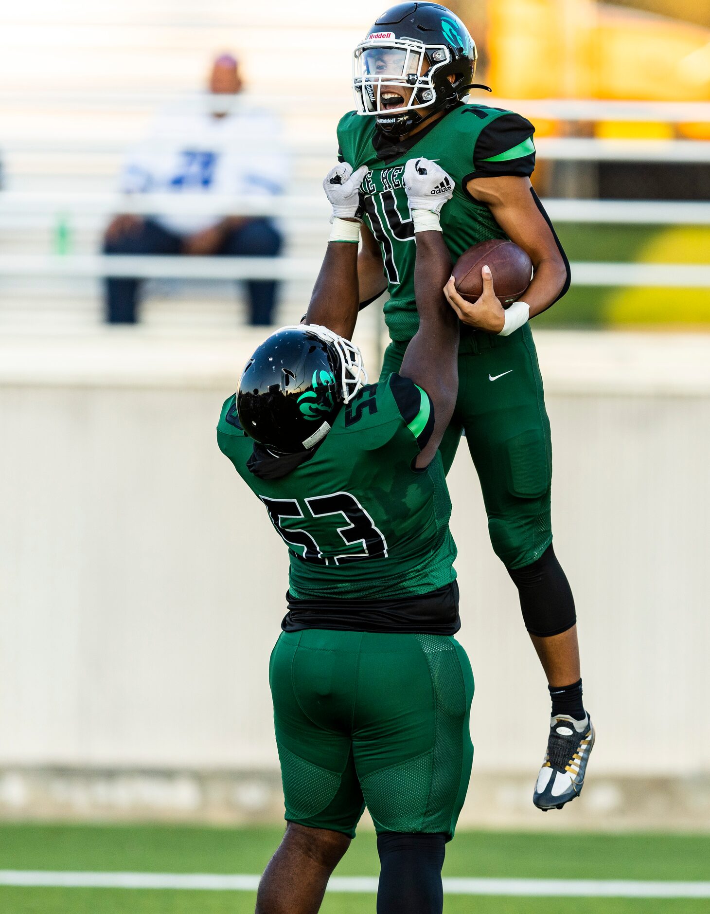 Berkner sophomore quarterback Cornell McGee IV (14) is lifted up in celebration by senior...