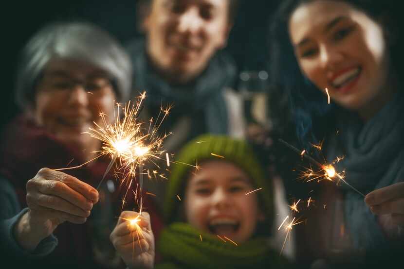 Family having fun with sparklers on New Years.