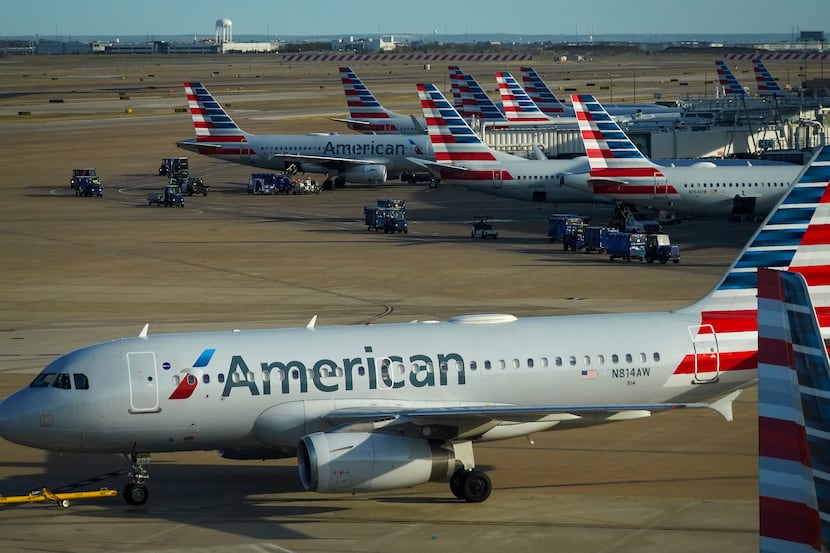 American Airlines planes are seen at the gates of Terminal C as another is towed past at DFW...