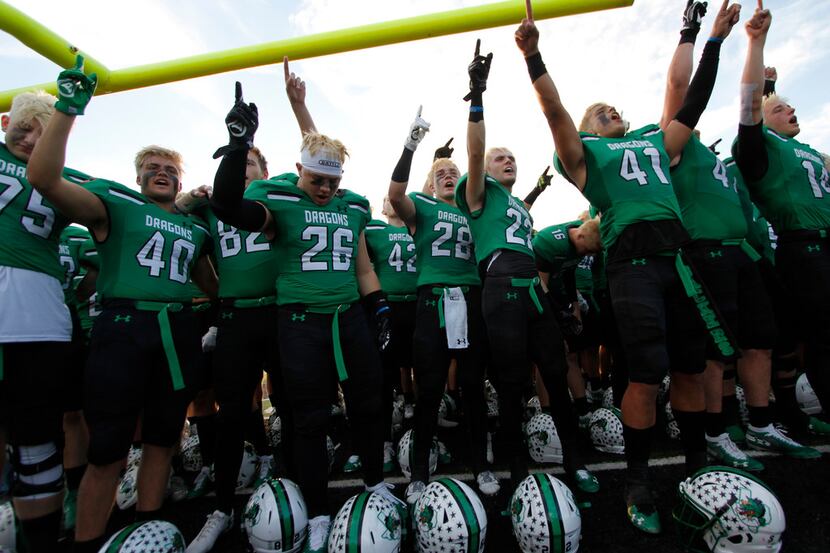 Members of the Southlake Carroll Dragons celebrate after the playing of their school song...