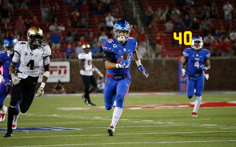 SMU defensive back Jordan Wyatt (15) returns an interception for a touchdown past UCF wide...