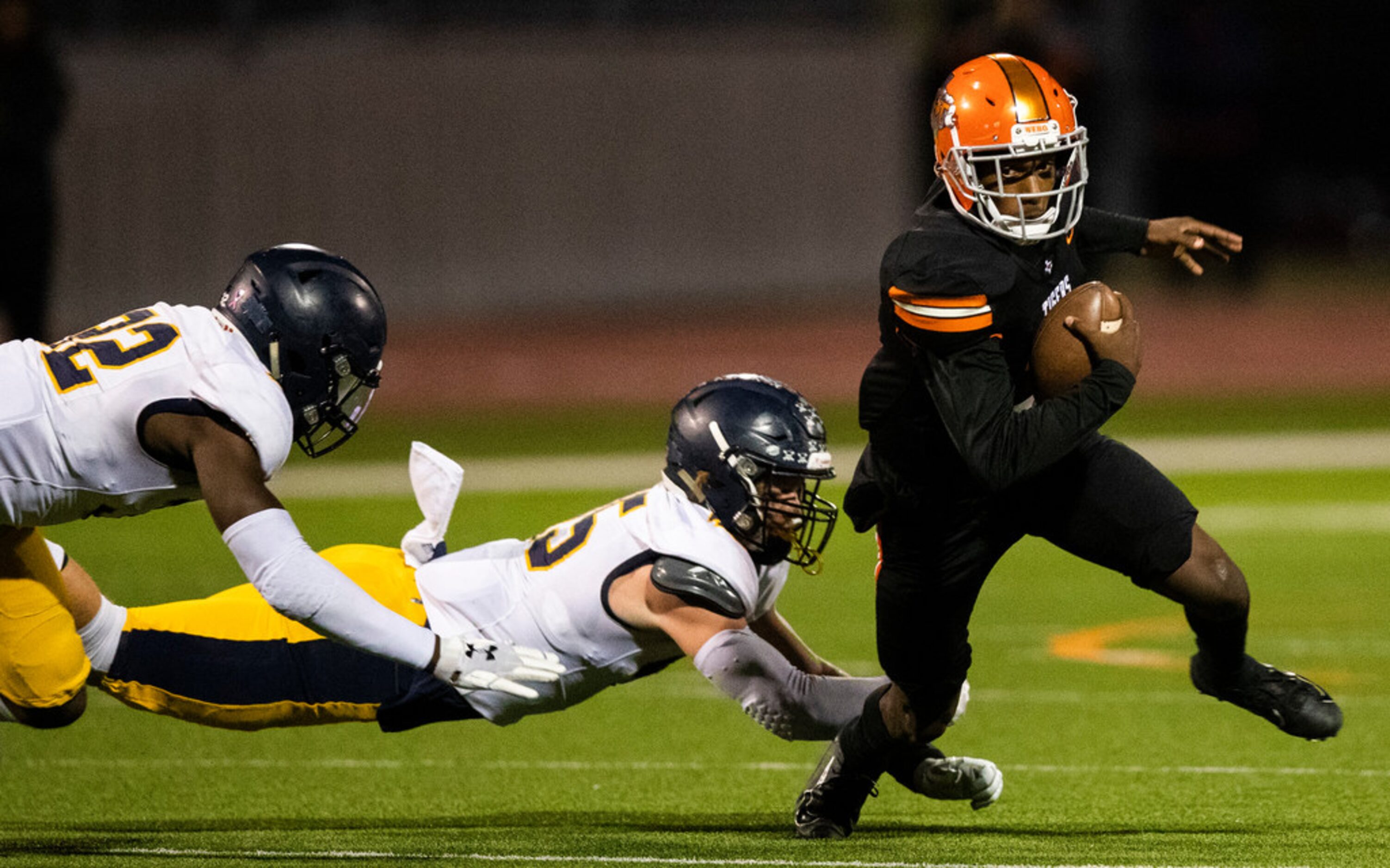 Lancaster quarterback Glenn Rice Jr. (3) escapes a tackle attempt by Highland Park defensive...