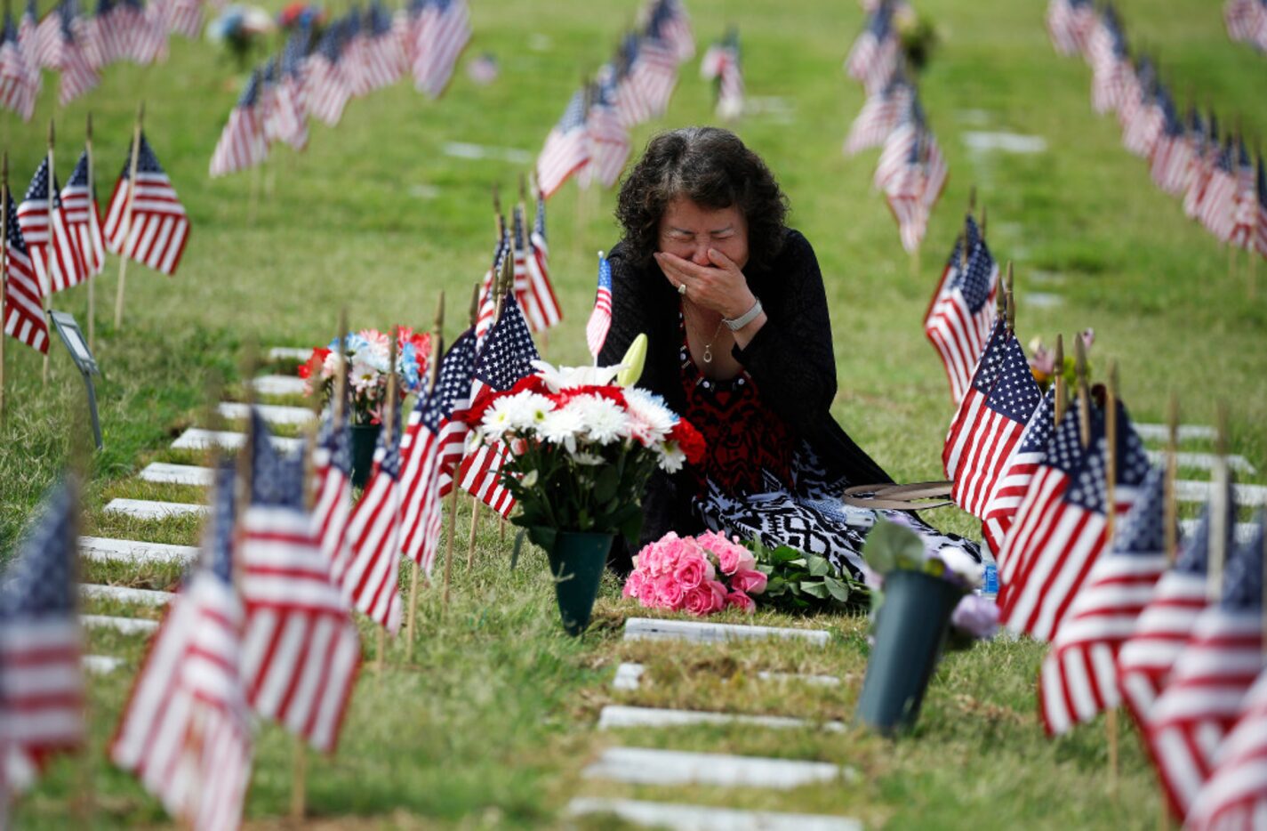 Una Pemberton, of Wichita Falls mourns at the grave of her son, Clem J. Strait III, who...