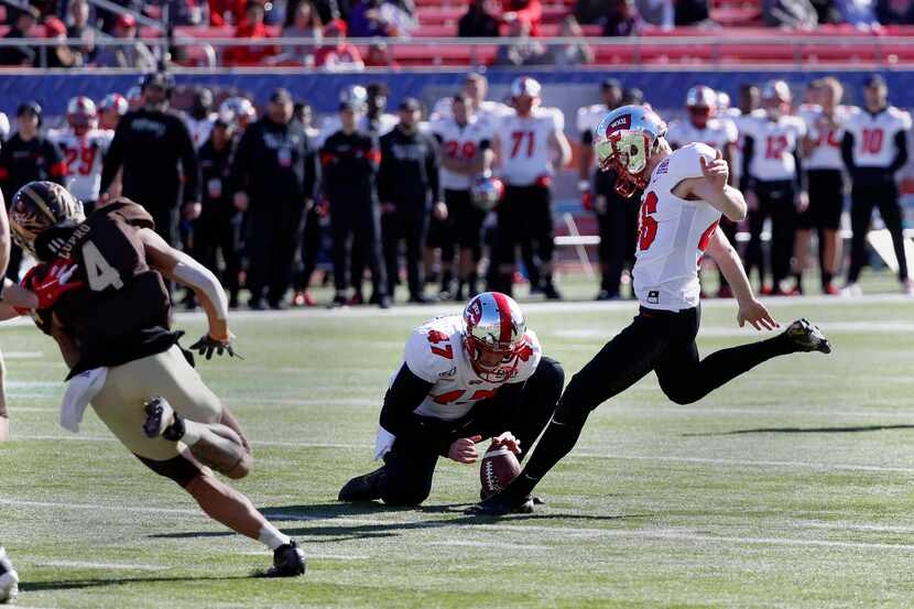 Western Kentucky place kicker Cory Munson, right, kicks a field goal from the hold of John...