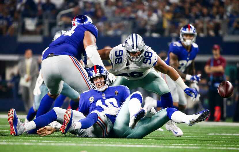 New York Giants quarterback Eli Manning (10) after getting sacked and fumbling the ball by...