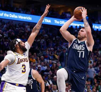 Dallas Mavericks guard Luka Doncic (77) shoots over a defending Los Angeles Lakers forward...