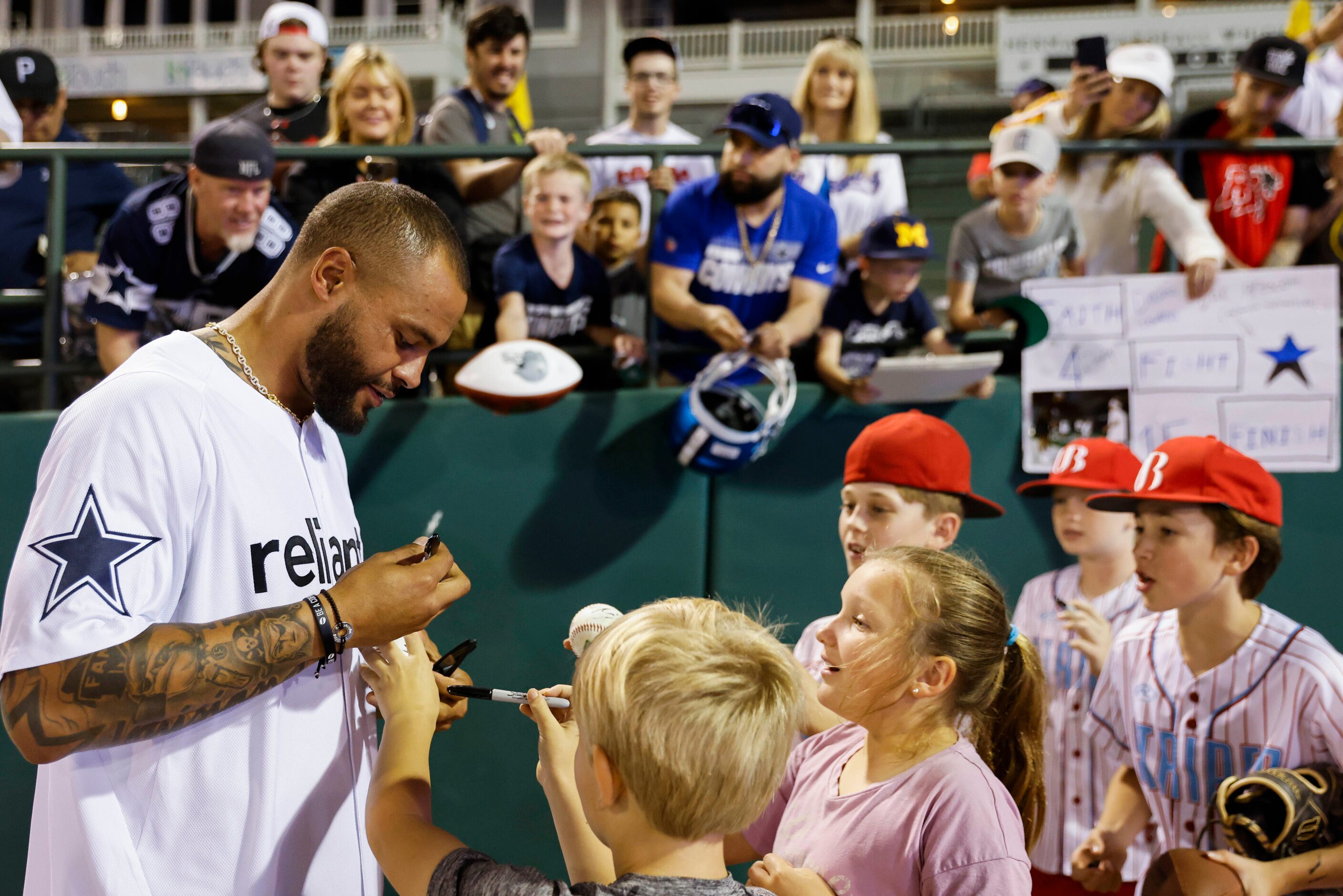 Dallas Cowboys QB Dak Prescott gives autograph to young fans after the annual home run derby...