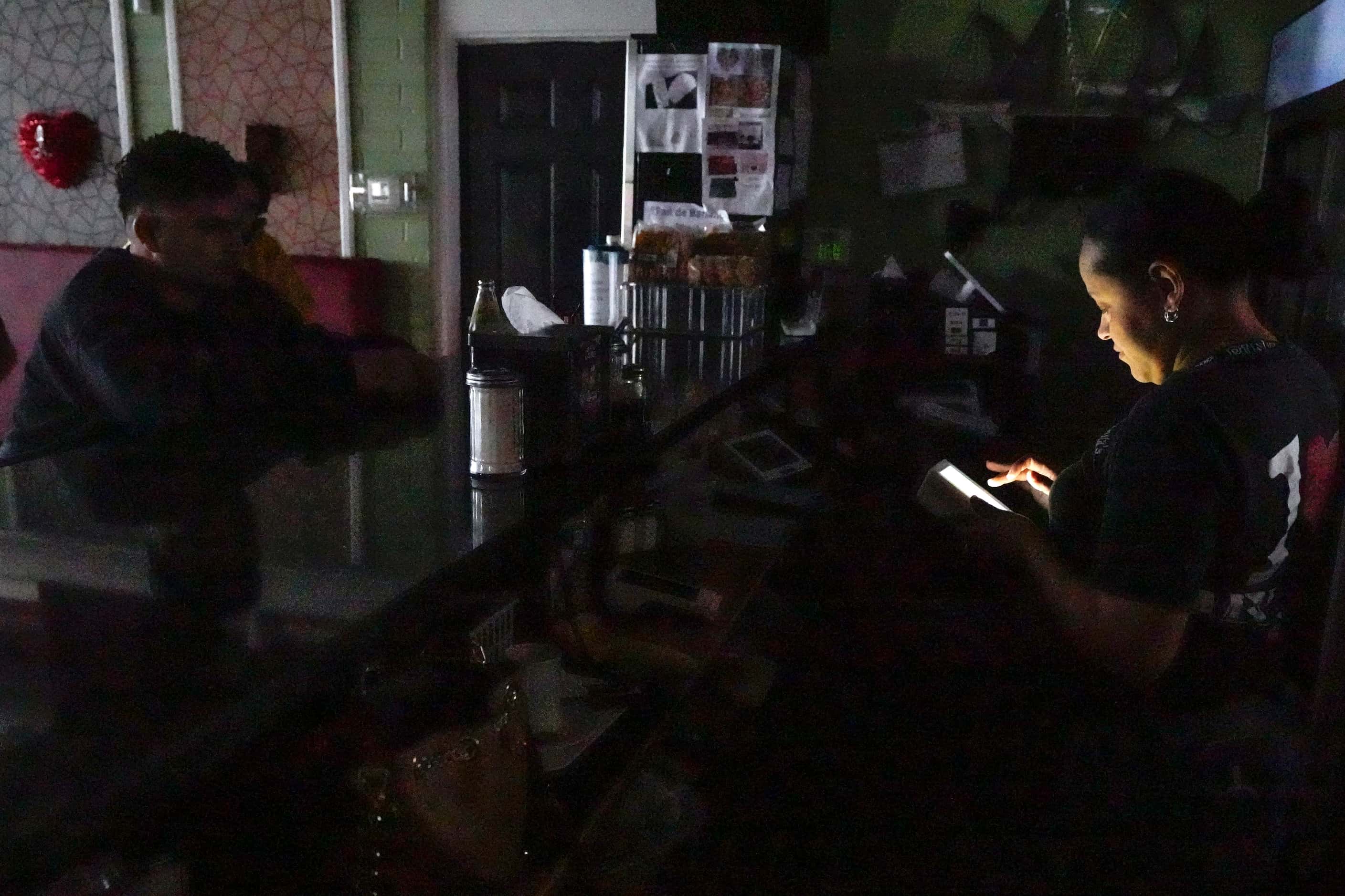 Ada Duarte takes to go orders using only the light of her phone after losing power at...