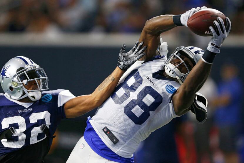 Dallas Cowboys wide receiver Dez Bryant (88) grabs a pass in the air as he is defended by...
