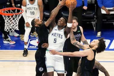 Minnesota Timberwolves guard Anthony Edwards (5) drives to the basket between Dallas...