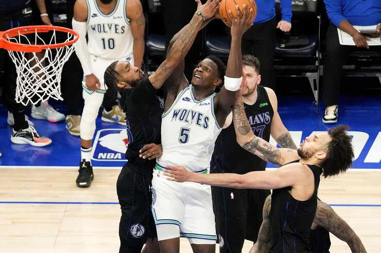 Minnesota Timberwolves guard Anthony Edwards (5) drives to the basket between Dallas...