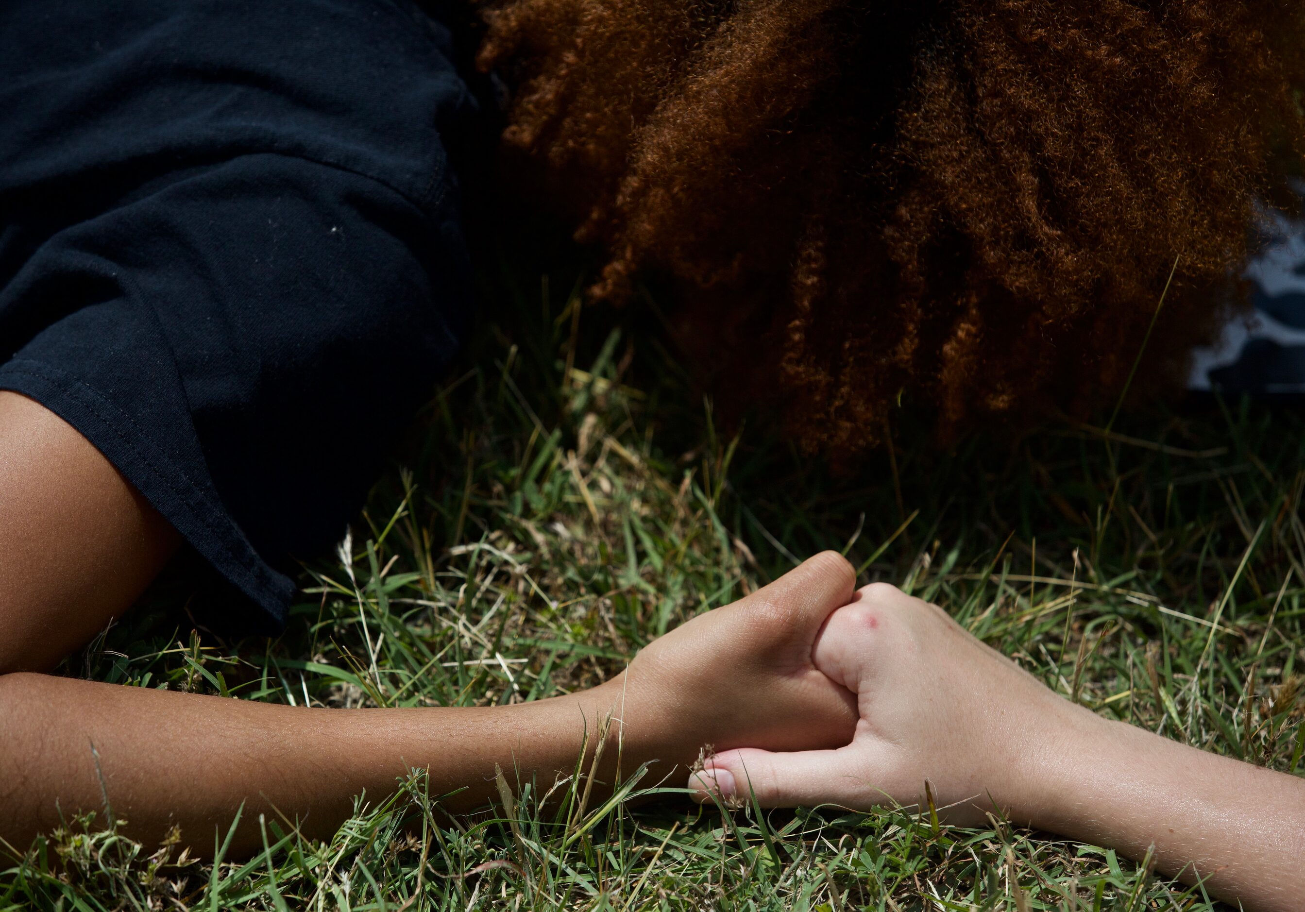 Co-organizers Sharon Iweajunwa (left) and Emily Boyd weep and hold hands while laying...