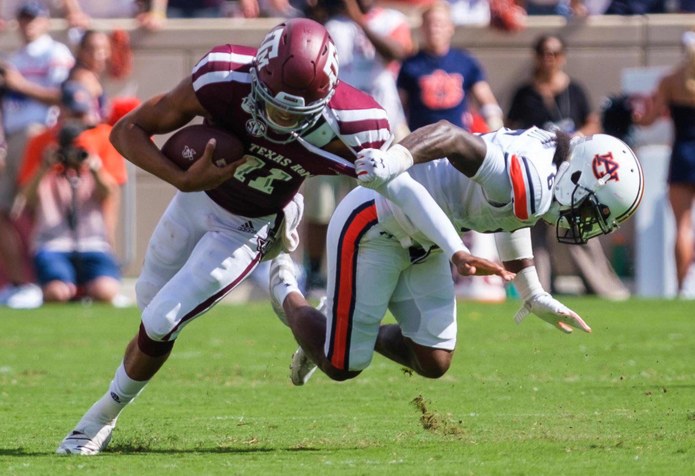 Texas A&M quarterback Kellen Mond (11) is pulled down by Auburn defensive back Christian...