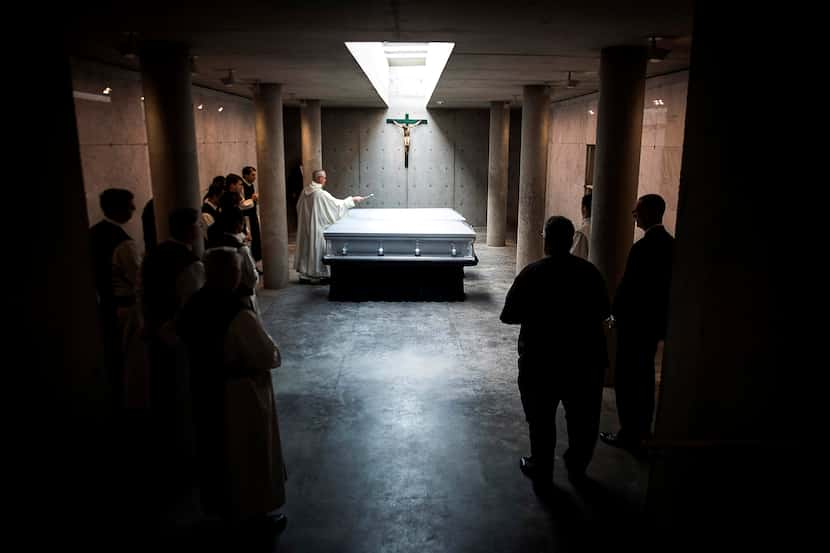 The Rev. Peter Verhalen, abbot of Cistercian Abbey Our Lady of Dallas, sprinkles holy water...