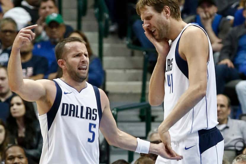 Dallas Mavericks forward Dirk Nowitzki, right, of Germany, touches his face after being...