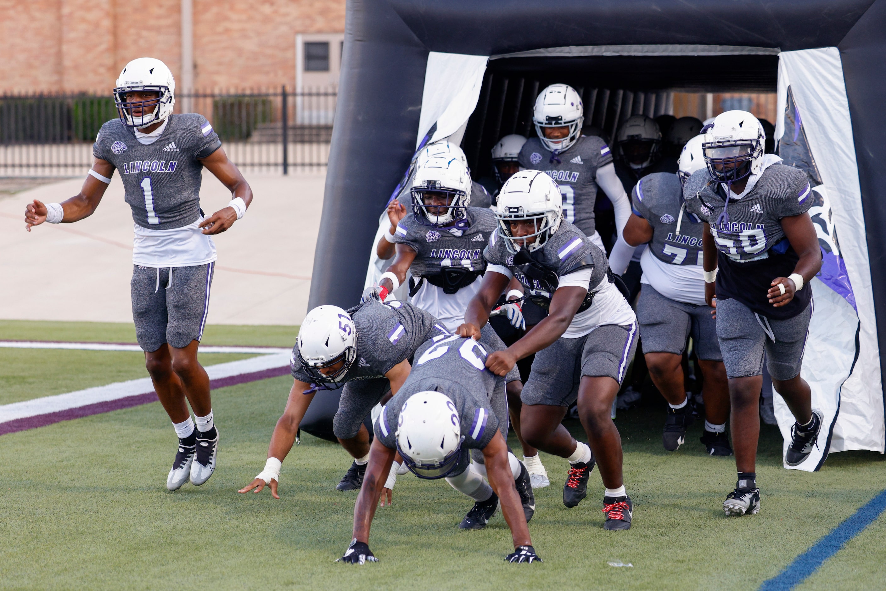 The Lincoln football team takes the field before the first half of a District 8-4A high...