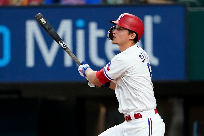 Texas Rangers' Corey Seager follows through on a two-run home run swing in the eighth inning...