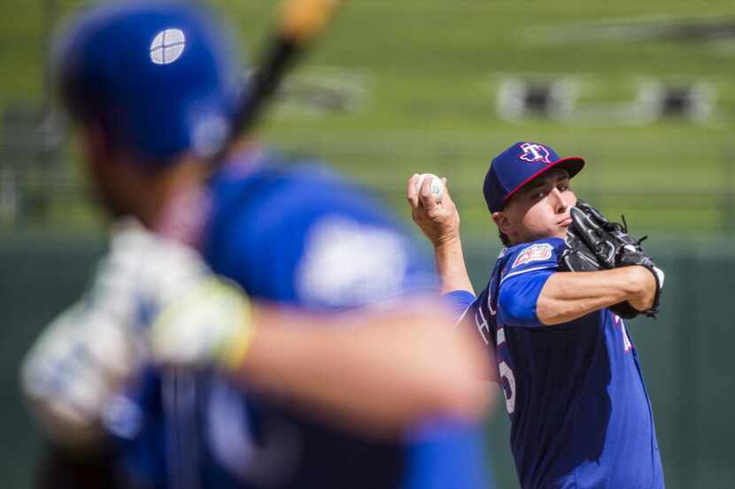 Texas Rangers pitcher Derek Holland pitches to Kansas City Royals third baseman Mike...