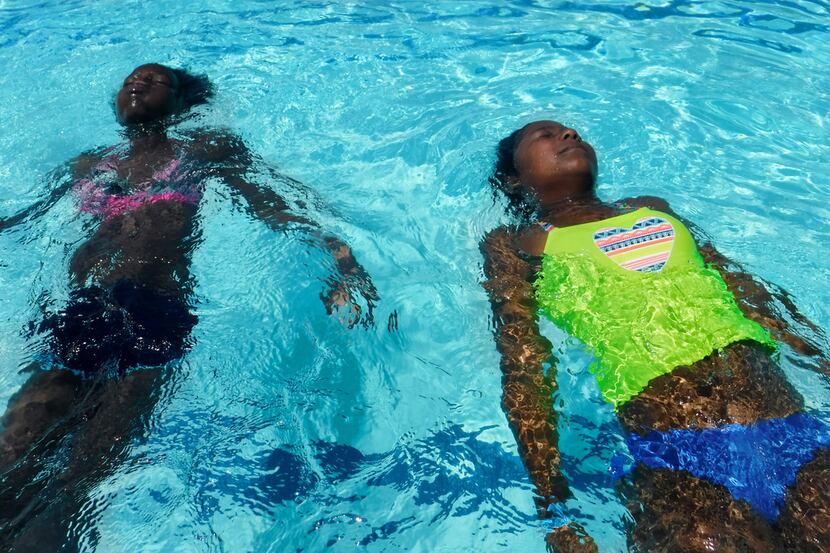 Rawterrian Rodgers, 11, left, and Kimora Abdullah, 10, both of Dallas, float on their backs...