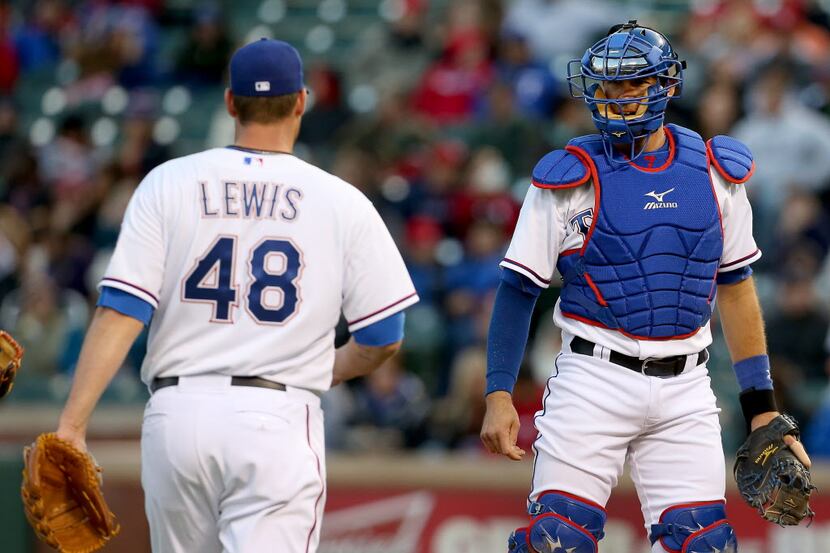 Texas Rangers catcher J.P. Arencibia (7) talks with starting pitcher Colby Lewis (48) in the...